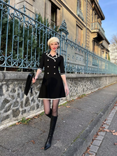 A young lady wears a double breasted dress